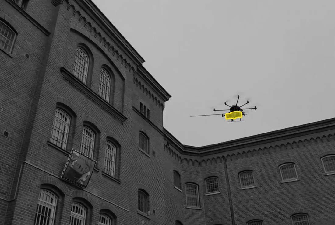 Dron přenášející balíček do soukromé věznice